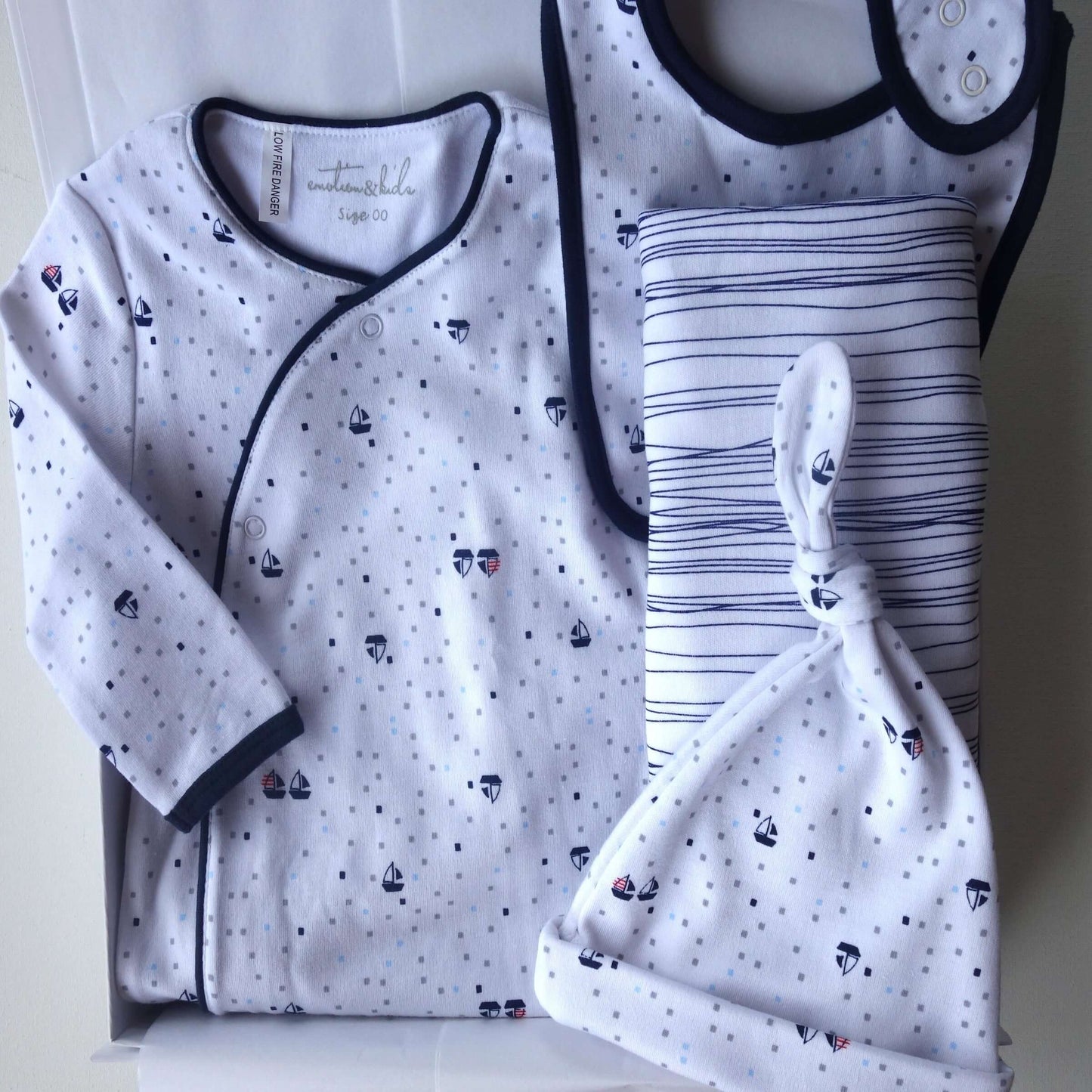 Hey Baby curated newborn gift box with blue and white cotton bodysuit, wrap, beanie, and bib.