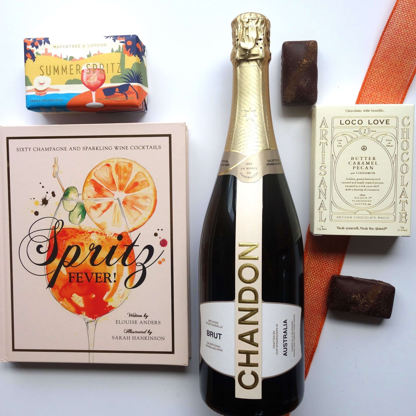 Summer celebration gift box featuring sparkling wine, cocktail book, and artisanal chocolates.