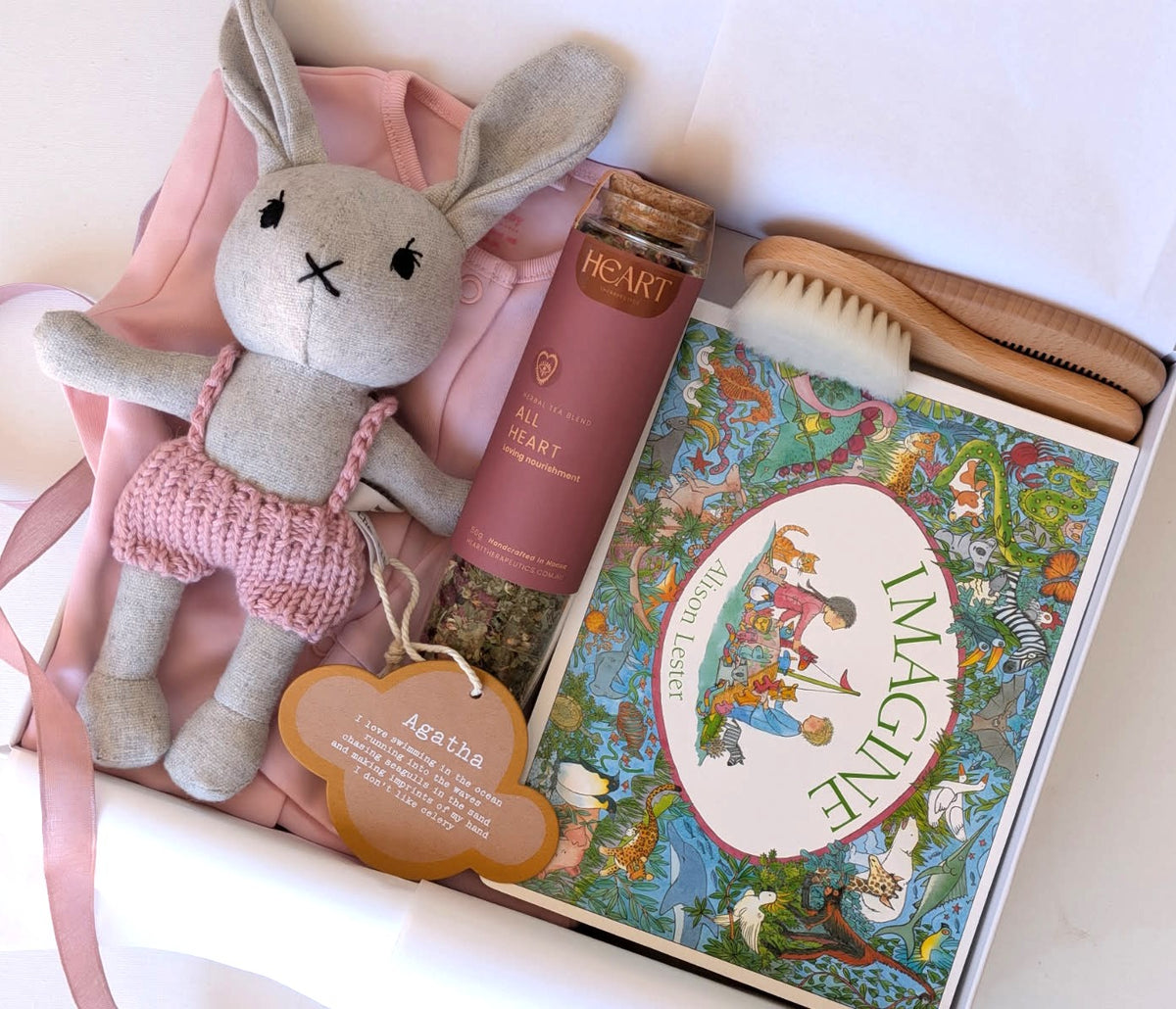 Welcome baby girl gift set featuring Agatha Rabbit, a soft toy, pink bodysuit, and a storybook for comfort and joy.