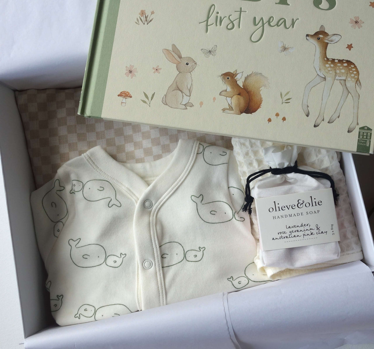 Unisex baby gift hamper featuring a record book, baby clothes, and handmade soap in a beautifully arranged box.