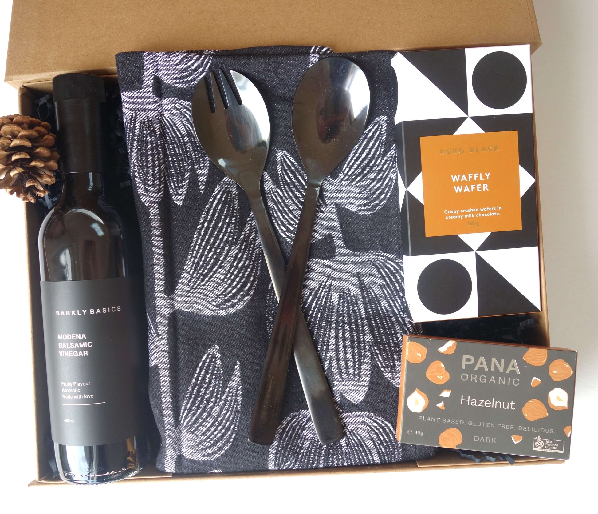 Homely Gift Hamper featuring balsamic vinegar, stylish tea towel, salad servers, Koko chocolate, and Pana hazelnut chocolate.