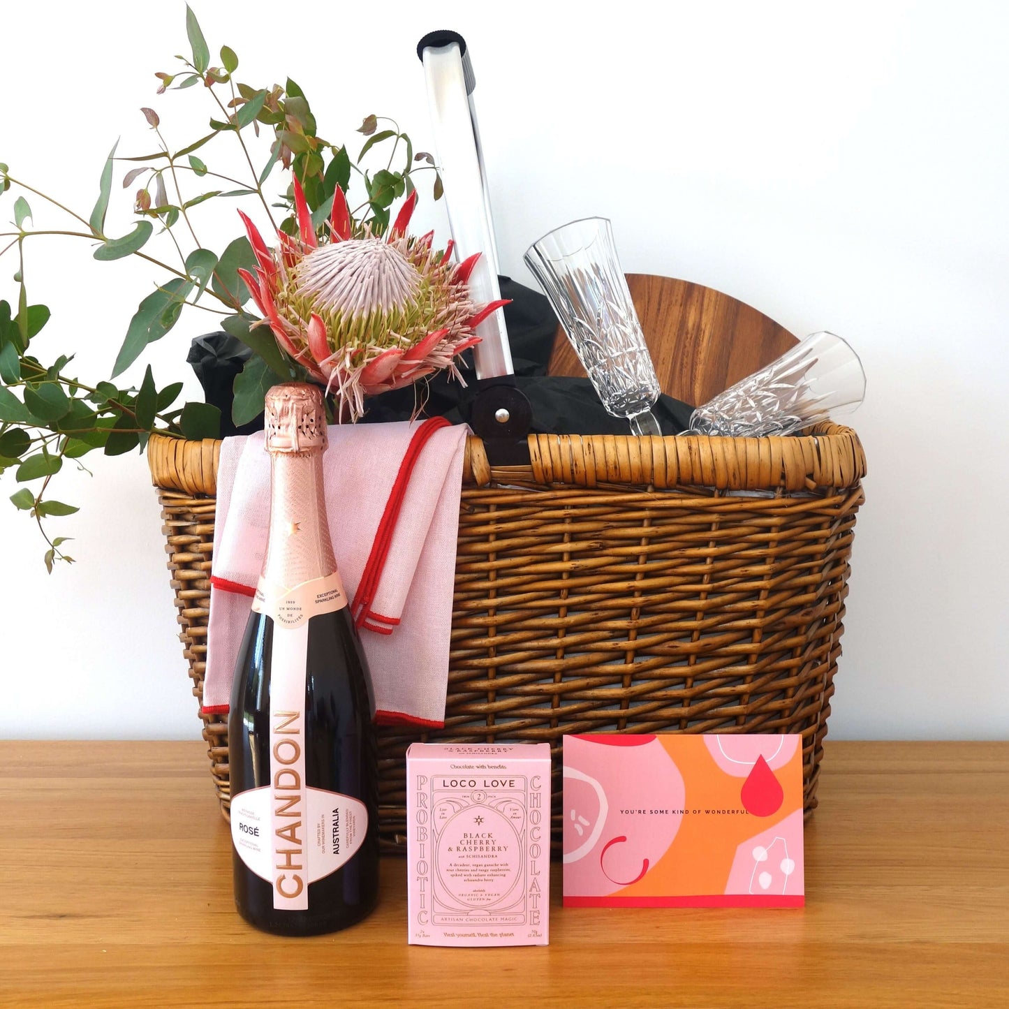 Hobart picnic gift basket featuring Chandon, glasses, and a floral arrangement for a perfect outdoor celebration.
