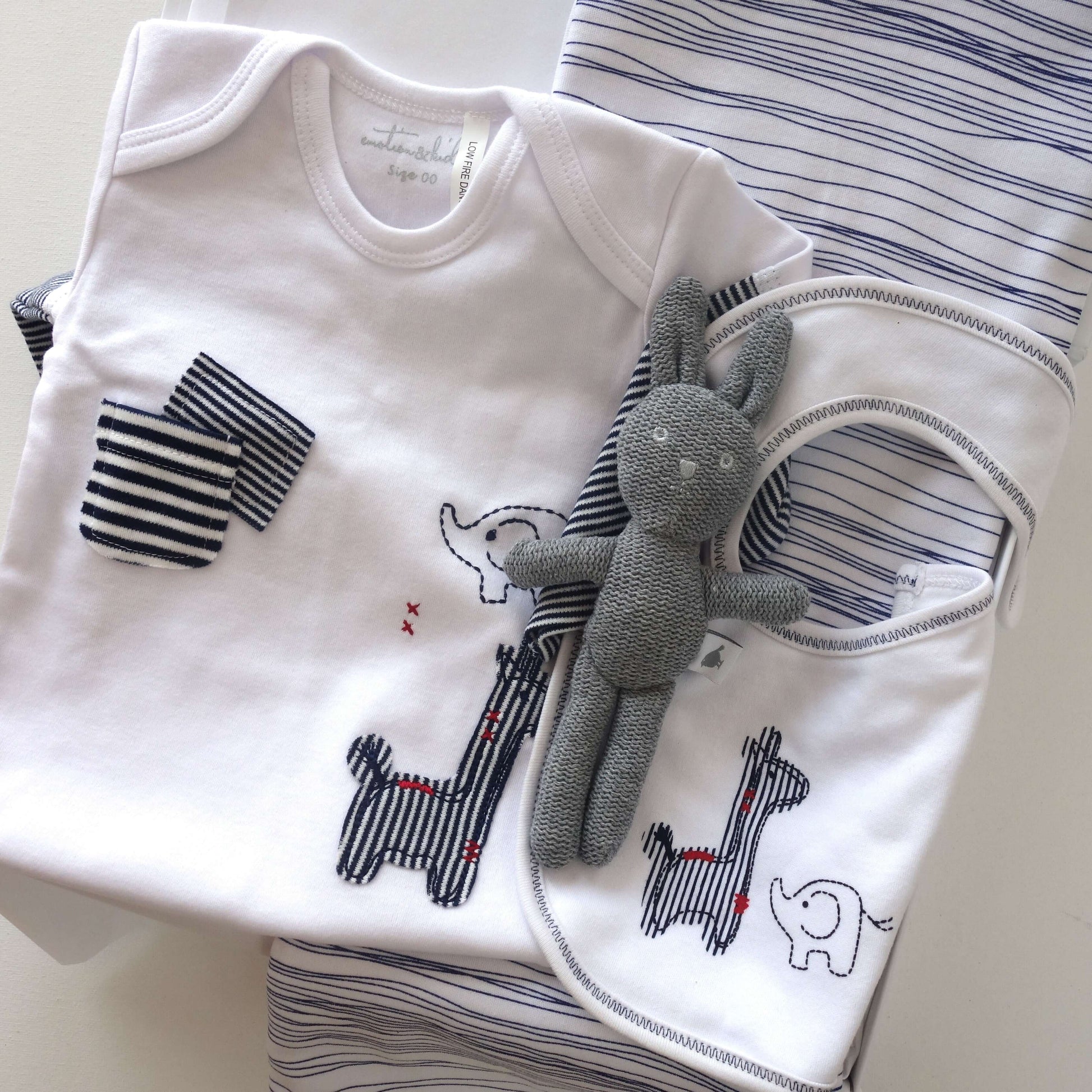 Classic navy and white baby gift box containing baby clothes and a plush toy.