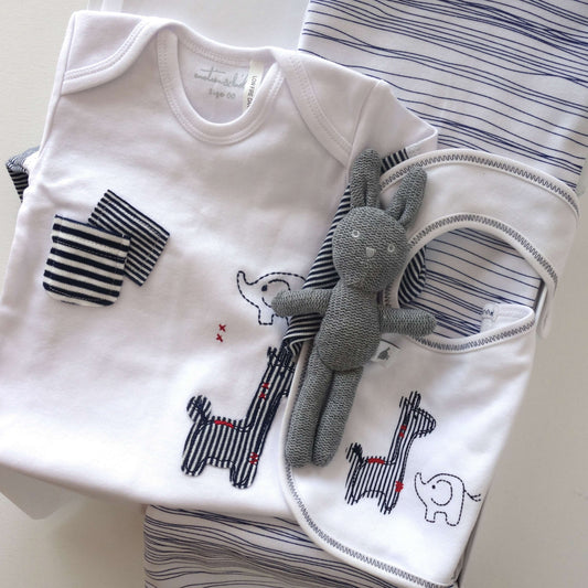 Classic navy and white baby gift box containing baby clothes and a plush toy.