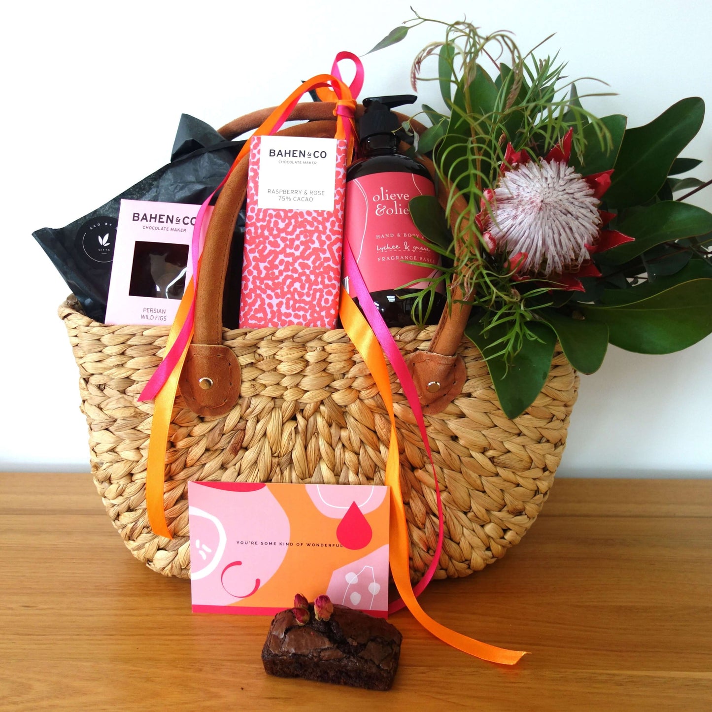 Mother's Day gift basket with home-baked brownie, beauty products, and fresh floral elements.