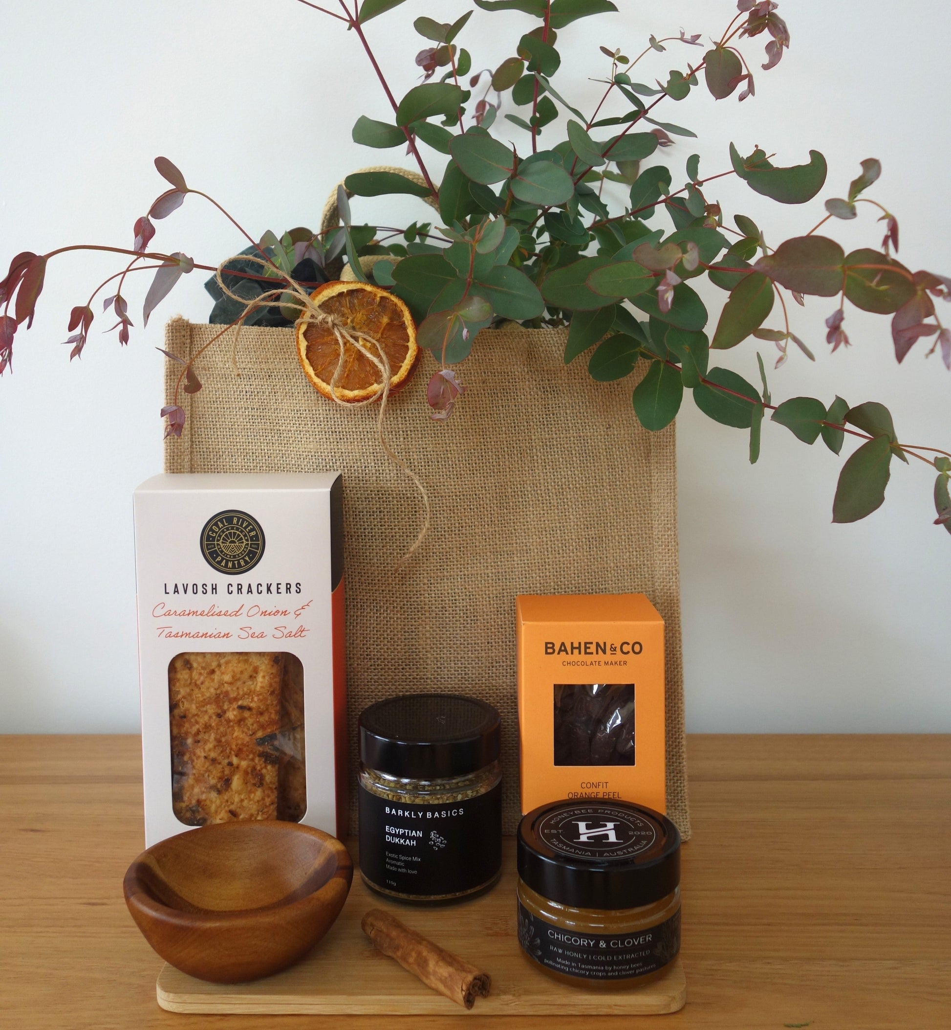 Thank you gift hamper Tasmania featuring Lavosh crackers, honey, chocolate, spices, and a jute bag with botanic greenery.