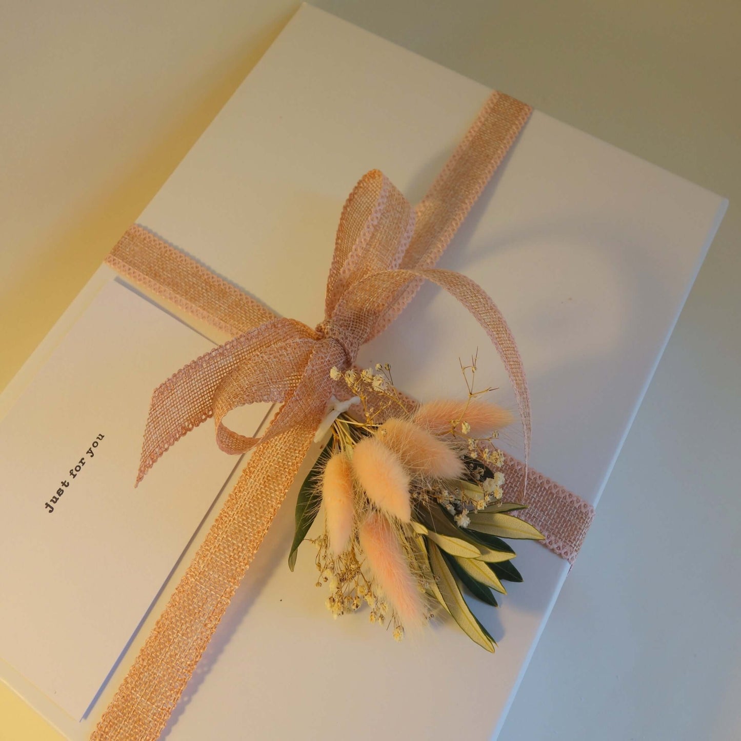Tasmanian gin lover's gift box elegantly wrapped with a pink ribbon and floral accents.