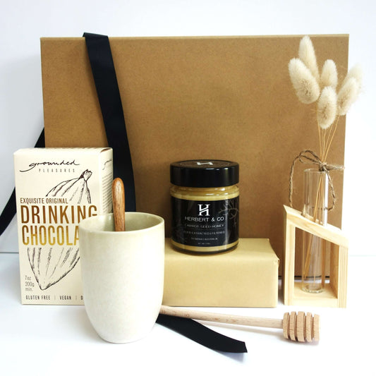 A Gift of Kindness featuring a get well gift box with drinking chocolate, honey, mug, and decorative items.